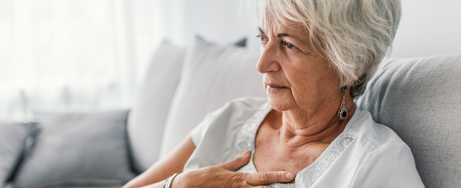 Patient experiencing heart burn looking for relief by putting their hand on their chest 