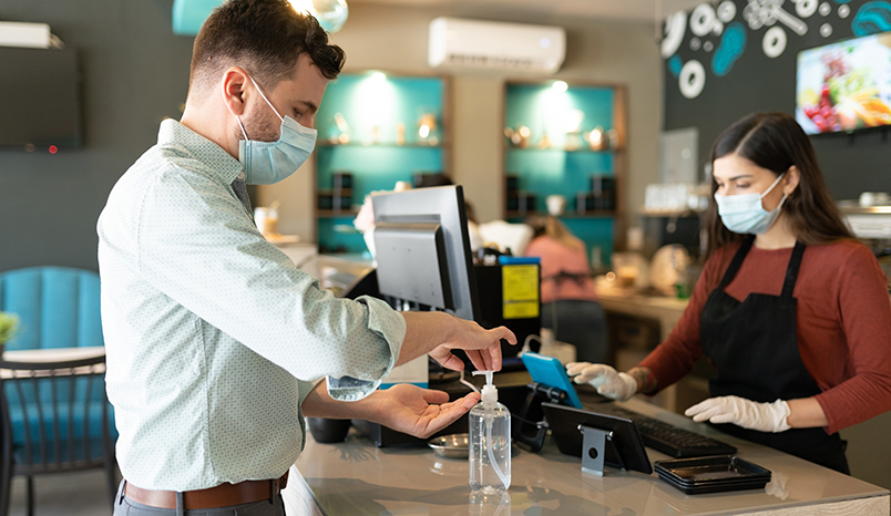 man-using-hand-sanitizer-at-store