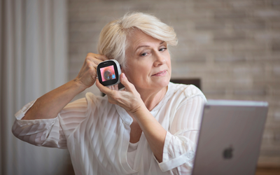 Woman uses TytoCare device.