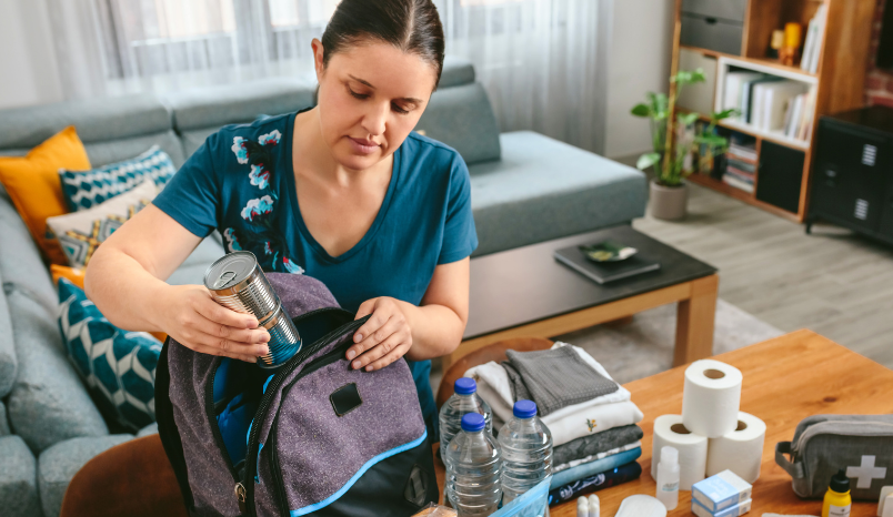 Woman prepares emergency backpack.