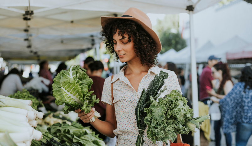 Woman looks at vegetable selection at local farmers market.