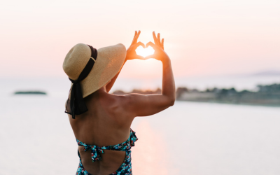 Woman in sun hat looks at sunset.