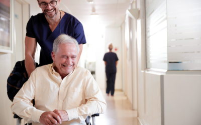 Nurse pushes patient in wheelchair.