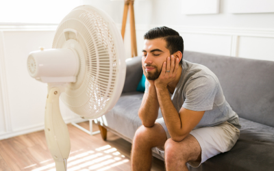 Man cools off in front of fan.