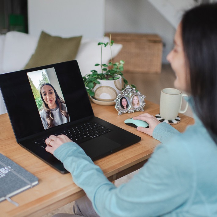 Woman attending virtual call on laptop in home office