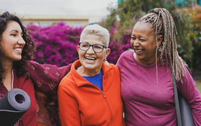 Multi generational women having fun hugging each other after yoga class at city park