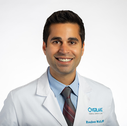 Headshot of Dr. Reuben Walia, a male physician with dark hair, in a white physician's coat and tie