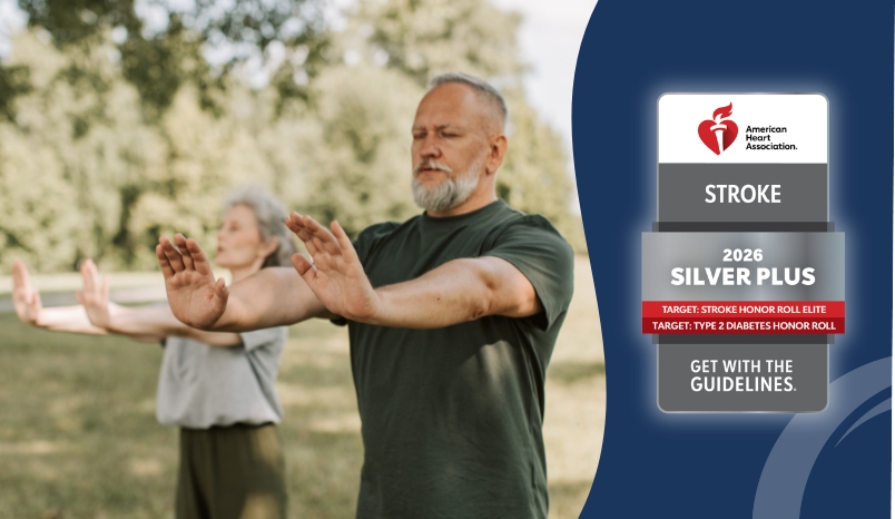 AHA Get with the Guidelines Silver Plus Stroke 2026 emblem alongside photo of couple outstretching their hands, side by side, in a park