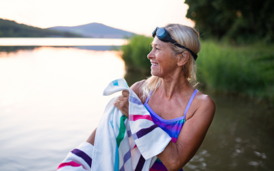  Portrait of active senior woman swimmer drying herself with towel outdoors by lake