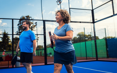 Woman and man on court playing game of pickleball.