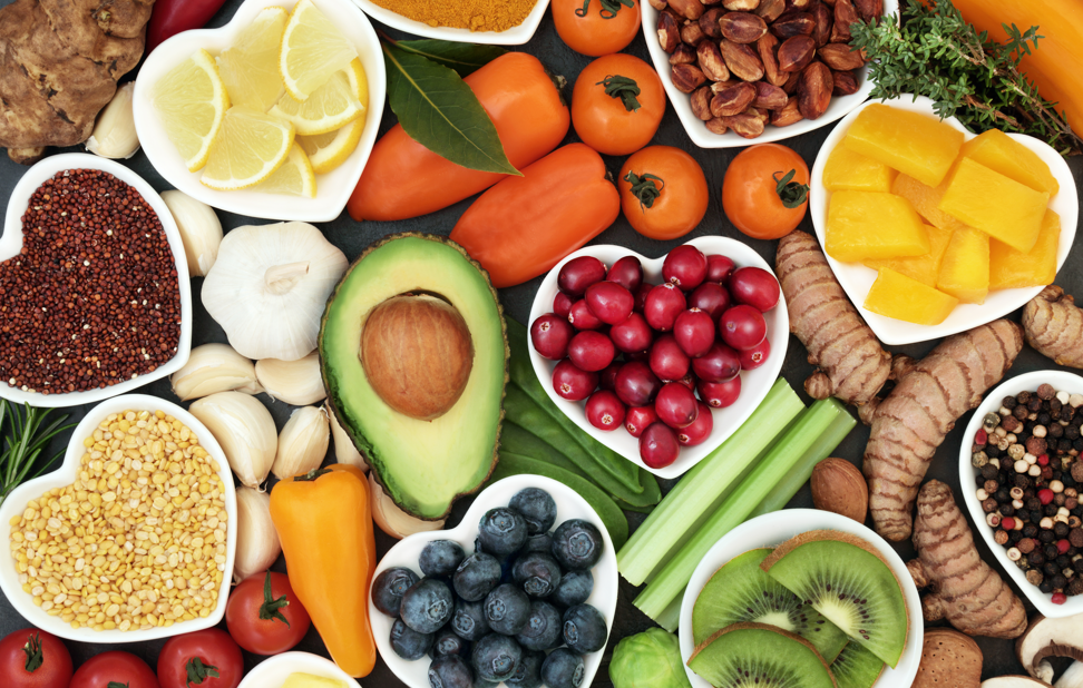 A spread of assorted fruits and grains, some in white, heart shaped bowls
