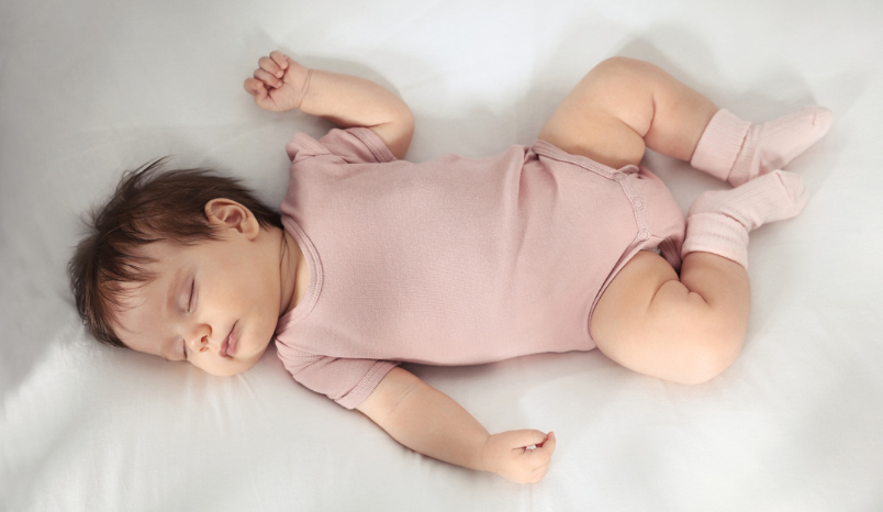 Baby sleeping on back in crib 