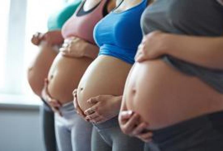 Four pregnant people standing together