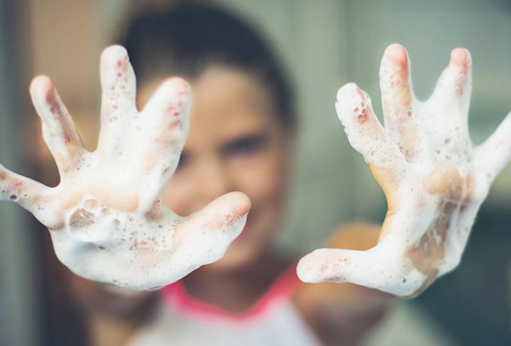 Hand covered in soap being cleaned