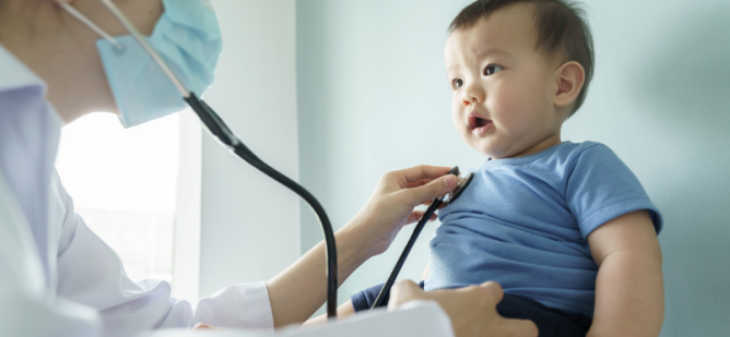 Doctor examines baby in office.
