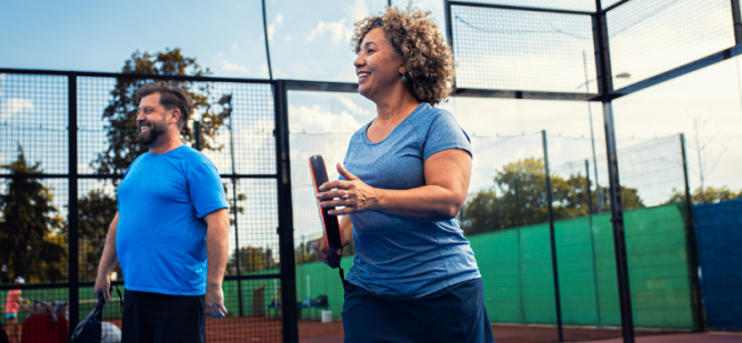 Woman and man on court playing game of pickleball.