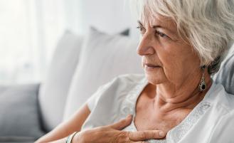 Patient experiencing heart burn looking for relief by putting their hand on their chest 