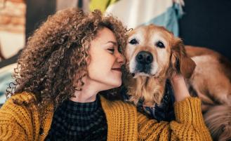 Person petting dog and smiling 