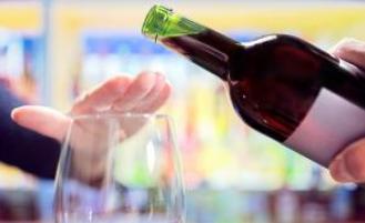 Person declining a refill of their wine glass.