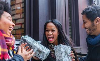 Three friends exchanging gifts