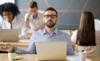 Person meditating at their desk