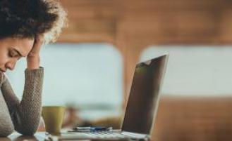 Person suffering from a migraine at computer