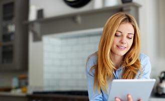A person checking their email in their kitchen on a tablet device 