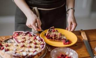 Person plating a raspberry pie