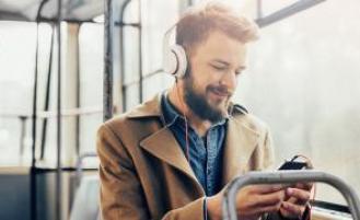 A person listening to something on their smart phone while riding the bus.