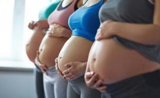 Four pregnant people standing together