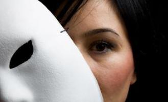 Person holding up a mask in front of their face