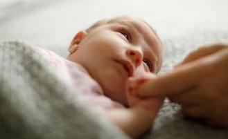 Infant holding hands with parent