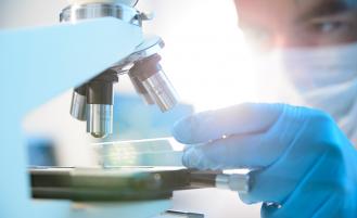Doctor reviewing sample under a microscope