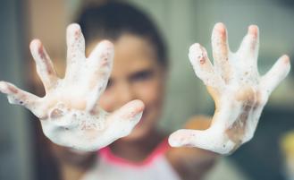 Hand covered in soap being cleaned