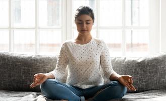 woman meditating on couch