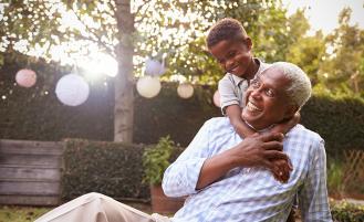 grandson-hugging-grandfather-on-lawn