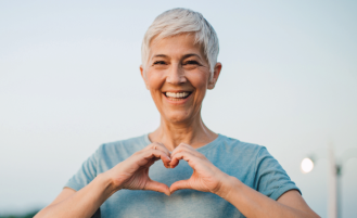 Woman holds her hands in a heart shape.