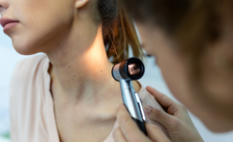 Dermatologist examines patient's skin.