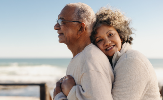 Older adults embracing on a beach.