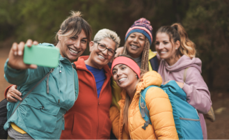 Women on hike stop and pose for a picture.