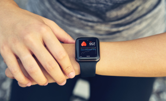 Person looks at smartwatch to check heart health.