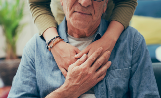 Person embraces older man.