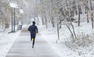 Person runs on snowy track.