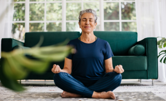 Older woman sits in lotus position while practicing yoga.
