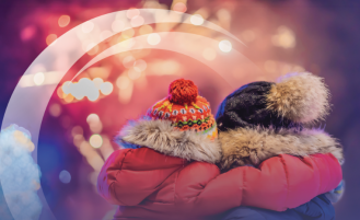 Parent and child in winter attire looking at fireworks.