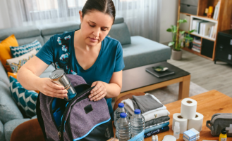 Woman prepares emergency backpack.
