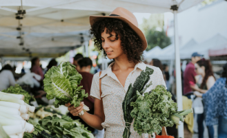 Woman looks at vegetable selection at local farmers market.