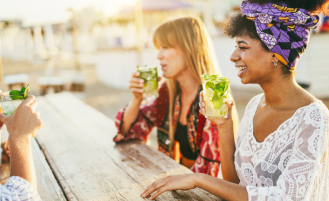 Women drink mocktails outside.