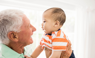 Grandparent holds grandchild.