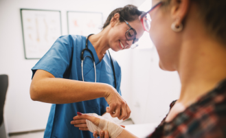 Nurse wraps patient's arm in guaze.